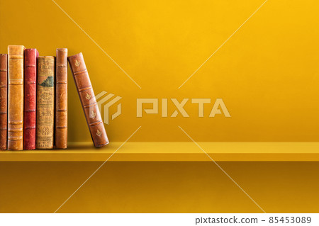 Row of old books on yellow shelf. Horizontal background Row of old books on yellow shelf. Horizontal background 85453089