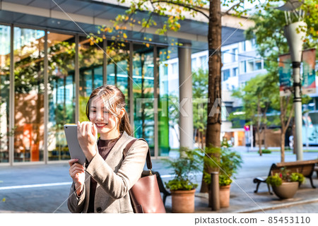 A young business woman operating a tablet in Tokyo Marunouchi A young business woman operating a tablet in Tokyo Marunouchi 85453110