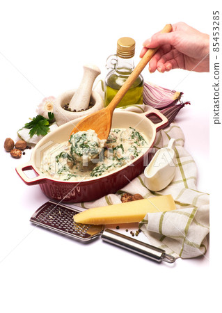Delicious meatballs with spinach in a creamy sauce in baking dish on white background Delicious meatballs with spinach in a creamy sauce in baking dish on white background 85453285