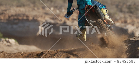 Racer boy on motorcycle participates in motocross race, active extreme sport, flying debris from a motocross in dirt track 85453595