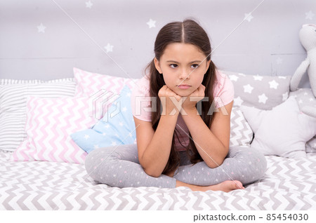 Unhappy cutie. Unhappy baby sit in bed. Little child Unhappy cutie. Unhappy baby sit in bed. Little child 85454030