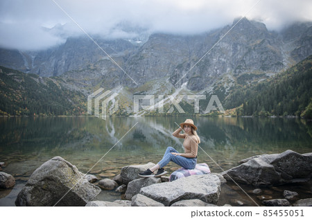 Young woman on a hiking trip sitting on a rock 85455051