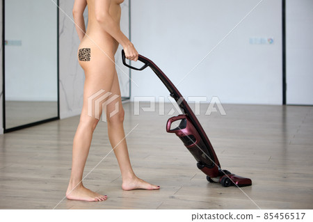 Vaccine passport is QR code on buttocks of nude cleaning lady with wireless vacuum cleaner. 85456517