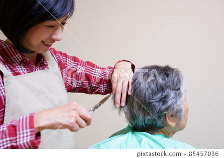 A woman who has a haircut for an elderly woman 85457036