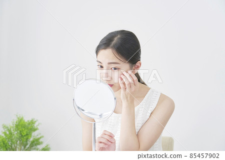 Woman looking at mirror Woman looking at mirror 85457902