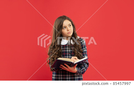 pondering kid making notes on red background, school 85457997
