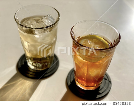 A landscape of black coasters laid on two glasses of iced tea and ginger ale A landscape of black coasters laid on two glasses of iced tea and ginger ale 85458338