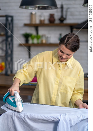 Housemaid ironing a wrinkled shirt with a steam iron Housemaid ironing a wrinkled shirt with a steam iron 85458965