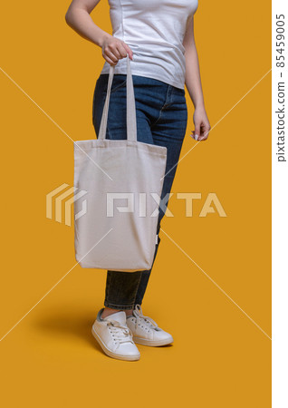 Female demonstrating her stylish bag before the camera 85459005