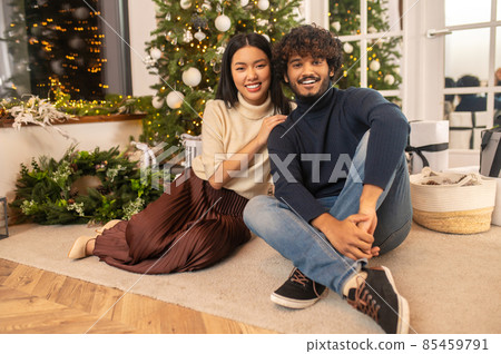 Woman and man looking at camera sitting on floor 85459791