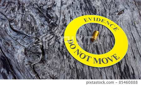 Bullet shell in middle of a yellow circle with text "evidence do not move" the circle on black background, concept for crime scene investigation Bullet shell in middle of a yellow circle with text "evidence do not move" the circle on black background, concept for crime scene investigation 85460888