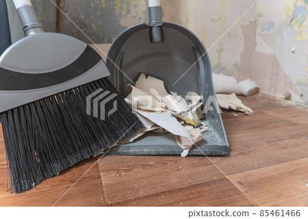 Clean up garbage after repairs.Sweep up construction debris with a brush in a dustpan.Sweeping at home.Tools for cleaning the house.Make home repairs.The dust.Wall repair.Torn wallpaper from the wall Clean up garbage after repairs.Sweep up construction debris with a brush in a dustpan.Sweeping at home.Tools for cleaning the house.Make home repairs.The dust.Wall repair.Torn wallpaper from the wall 85461466