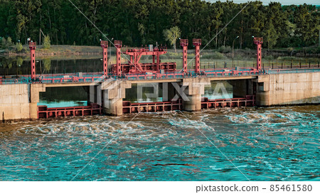 River, dam, bridge. Car and pedestrian bridge in the morning. A full-flowing river with a strong current. Clean, bubbling, fresh water.Technical construction on the river, fresh water reserves River, dam, bridge. Car and pedestrian bridge in the morning. A full-flowing river with a strong current. Clean, bubbling, fresh water.Technical construction on the river, fresh water reserves 85461580