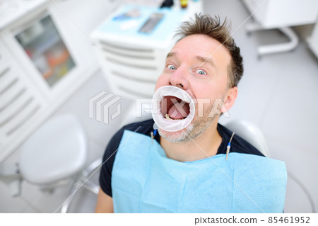 Frightened patient in the chair on dental clinic. Orthodontist and prosthetics appointment. Fear of dentists concept. Frightened patient in the chair on dental clinic. Orthodontist and prosthetics appointment. Fear of dentists concept. 85461952