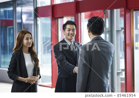 asian corporate executives shaking hands with visiting client in elevator hall of modern office building asian corporate executives shaking hands with visiting client in elevator hall of modern office building 85461954