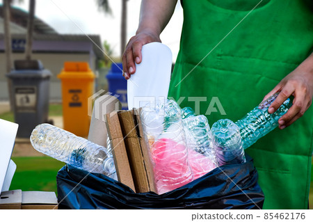 White wastes plastic containers sorting into black plastic bag by hands with blur garbage trashes White wastes plastic containers sorting into black plastic bag by hands with blur garbage trashes 85462176