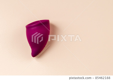 Bag shaped Menstrual cup on beige background 85462188