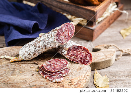 Smoked sliced salami on a old wooden table Smoked sliced salami on a old wooden table 85462292