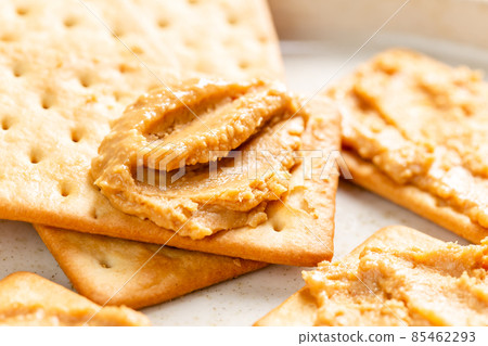 Peanut butter spread on soda crackers close up Peanut butter spread on soda crackers close up 85462293