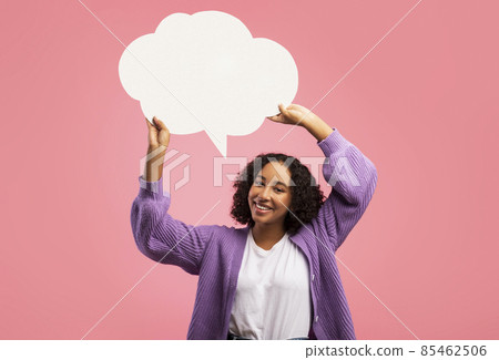 Cheerful black woman holding blank speech bubble on pink studio background, mockup for your ad design Cheerful black woman holding blank speech bubble on pink studio background, mockup for your ad design 85462506
