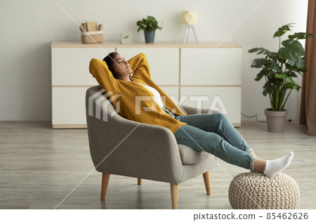 Relaxed arab woman resting in comfortable armchair, lady sitting in chair with hands behind head and closed eyes Relaxed arab woman resting in comfortable armchair, lady sitting in chair with hands behind head and closed eyes 85462626