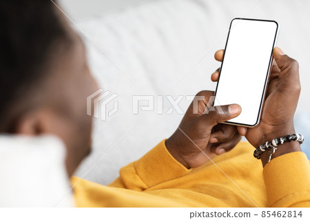 Unrecognizable black guy using mobile phone with empty screen Unrecognizable black guy using mobile phone with empty screen 85462814