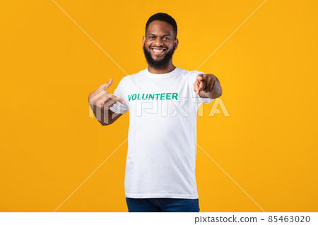 Black male volunteer pointing at t-shirt and at camera, studio Black male volunteer pointing at t-shirt and at camera, studio 85463020