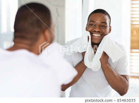 Male Beauty Care. Smiling African American Man Wiping Face With Towel In Bathroom 85463035