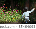 kindergarten girl running in flower garden 85464093