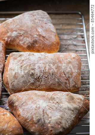 Batch of ciabatta bread on a cooling rack. Batch of ciabatta bread on a cooling rack. 85464772