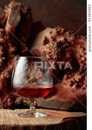 Snifter of brandy on an old dried stump. Snifter of brandy on an old dried stump. 85464963