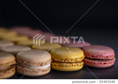 chocolate, coffee, vanilla, lemon and strawberry macaroons on black background chocolate, coffee, vanilla, lemon and strawberry macaroons on black background 85465046