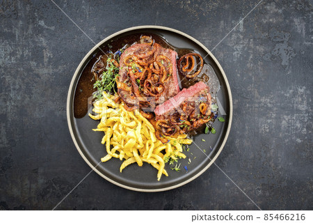dry aged sliced roast beef with fried onion rings and Swabian spaetzle dry aged sliced roast beef with fried onion rings and Swabian spaetzle 85466216