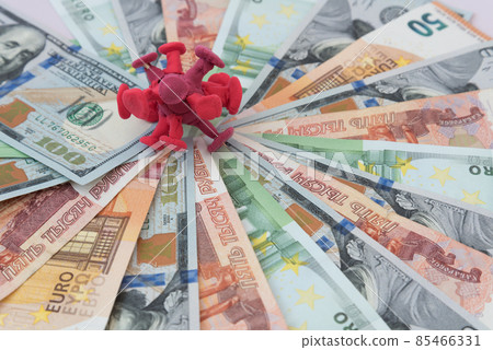 On the bills of different countries lies on top of the coronavirus. Dollar, euro, ruble bills. The concept of financial costs for the fight against coronavirus. Health care costs. Financing vaccine On the bills of different countries lies on top of the coronavirus. Dollar, euro, ruble bills. The concept of financial costs for the fight against coronavirus. Health care costs. Financing vaccine 85466331