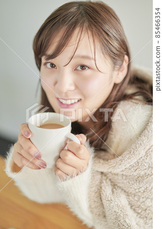 Young woman drinking coffee for a change during telework Young woman drinking coffee for a change during telework 85466354