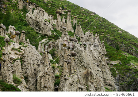 High rock formation with stone boulders at the top, standing on the side of a hill. Stone mushrooms, Altai, Siberia, Russia. 85466661