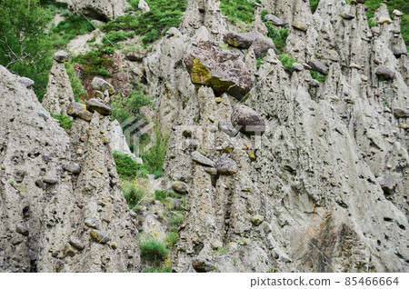 High rock formation with stone boulders at the top, standing on the side of a hill. Stone mushrooms, Altai, Siberia, Russia. High rock formation with stone boulders at the top, standing on the side of a hill. Stone mushrooms, Altai, Siberia, Russia. 85466664
