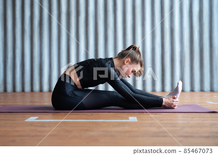 Woman leans forward stretches her back and legs. Woman leans forward stretches her back and legs. 85467073