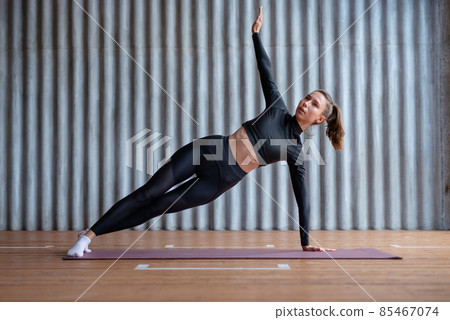 Young woman doing a side plank exercise Young woman doing a side plank exercise 85467074
