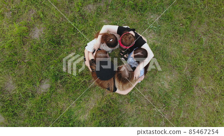 Friends hug in the park on a summer day. View from above. Friends hug in the park on a summer day. View from above. 85467254