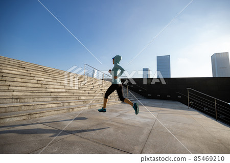 Fitness sports woman running up stairs in sunrise city Fitness sports woman running up stairs in sunrise city 85469210