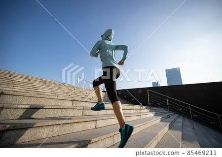 Fitness sports woman running up stairs in sunrise city Fitness sports woman running up stairs in sunrise city 85469211