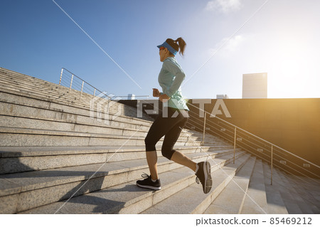 Fitness sports woman running up stairs in sunrise city Fitness sports woman running up stairs in sunrise city 85469212