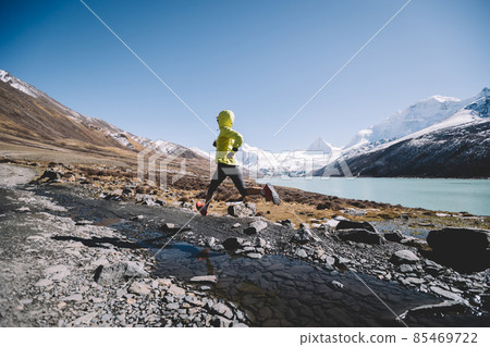 Woman trail runner running in winter mountains Woman trail runner running in winter mountains 85469722