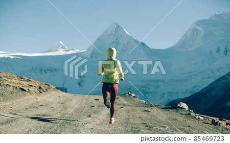 Woman trail runner running in winter mountains Woman trail runner running in winter mountains 85469723