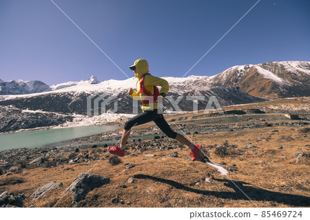 Woman trail runner in high altitude winter mountains Woman trail runner in high altitude winter mountains 85469724
