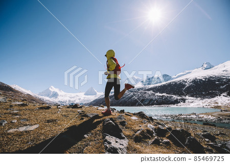 Woman trail runner in high altitude winter mountains Woman trail runner in high altitude winter mountains 85469725