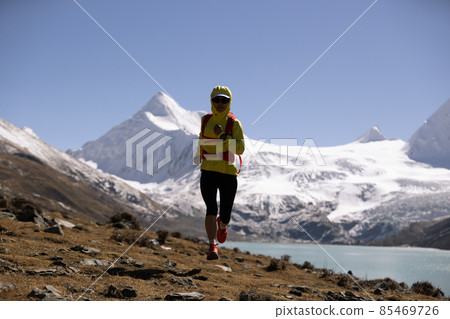 Woman trail runner in high altitude winter mountains Woman trail runner in high altitude winter mountains 85469726