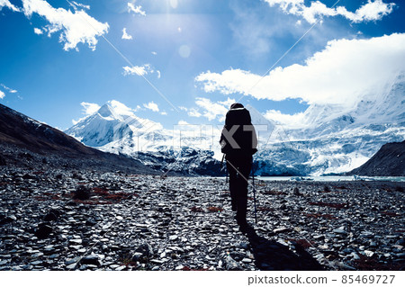 Woman backpacker hiking in winter high altitude mountains Woman backpacker hiking in winter high altitude mountains 85469727