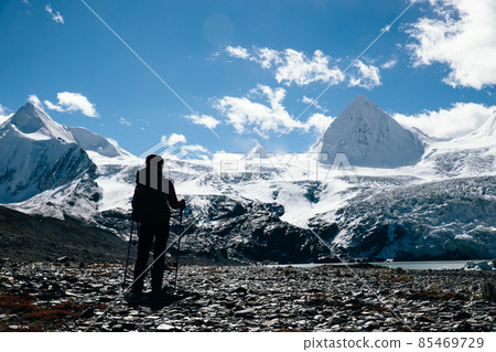 Woman backpacker hiking in winter high altitude mountains Woman backpacker hiking in winter high altitude mountains 85469729
